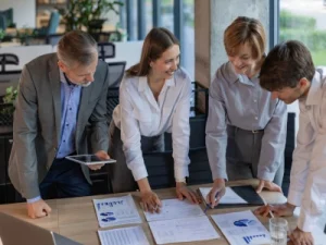Colaboradores revisando gráficos para aplicar técnicas de revenue management en la oficina.

